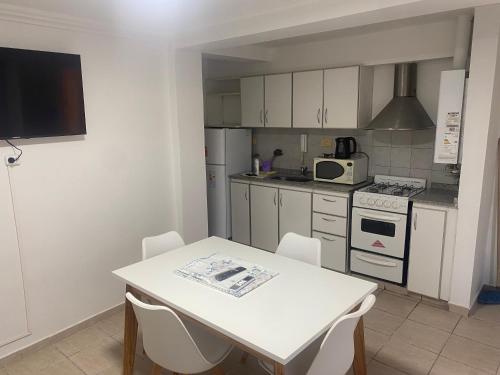 a kitchen with a white table and white appliances at Departamento av.Cordoba in San Juan