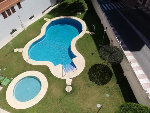 einen Blick über einen Pool im Hof in der Unterkunft Apartamento para la felicidad in Roquetas de Mar