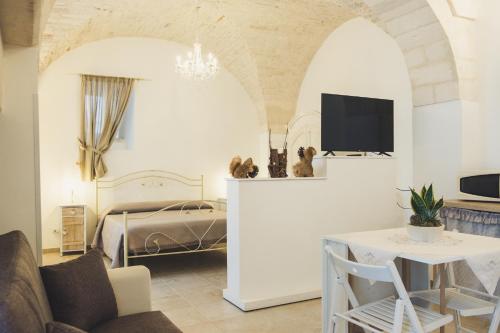 a bedroom with a bed and a table with a chair at Cà dei Palazzo - Guest House in Martina Franca