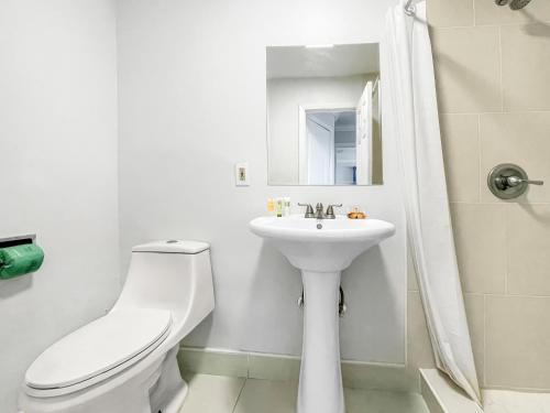 ein weißes Bad mit einem WC und einem Waschbecken in der Unterkunft The Seagull in Hollywood