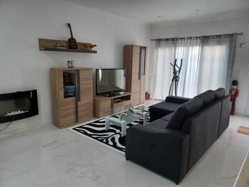 a living room with a couch and a tv at Casa da Linda in Ponta Delgada