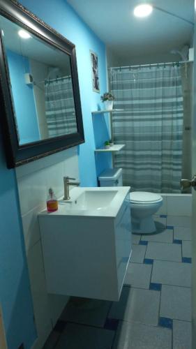 a bathroom with a sink and a toilet and a mirror at Lopez House in Lima