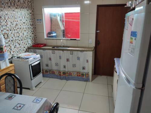 a kitchen with a refrigerator and a counter top at Casa Duplex Arraial do Cabo 30 metros do Mar in Arraial do Cabo