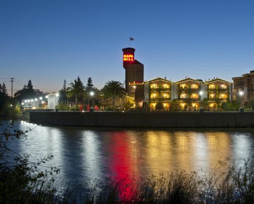 a building with a lit up tower next to a river at Napa River Inn in Napa