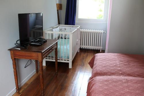 a bedroom with a bed and a desk with a television at Villa Mathilde in Saint-Pierre-en-Port