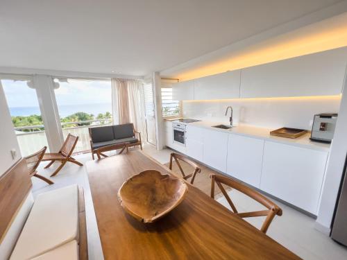 een keuken en eetkamer met een tafel en stoelen bij Appartement Toucan - Grand standing pleine vue mer in Saint-François