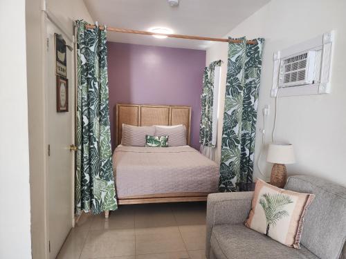a small bedroom with a bed and a chair at Old Town Suites in Key West