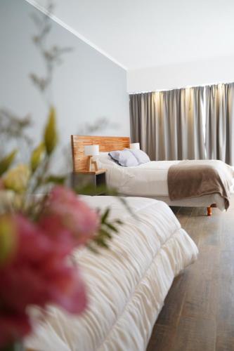 um quarto de hotel com duas camas e flores no primeiro plano em Patagonia Oeste em San Carlos de Bariloche