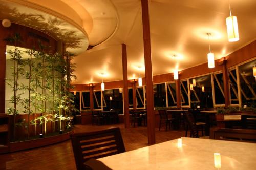 un restaurant avec une table, des chaises et des plantes sur le mur dans l'établissement Ying Shih Guest House, à Datong