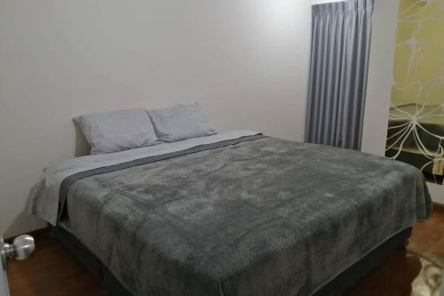 1 dormitorio con 1 cama con manta gris en Hermoso departamento en exclusivo Condominio en Arequipa