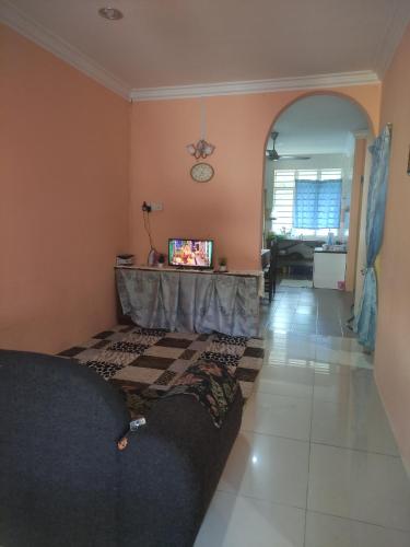 uma sala de estar com um sofá e uma televisão em Bayu Homestay em Kampong Gong Surau