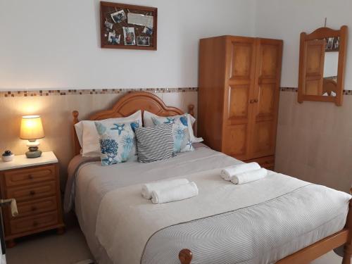 sypialnia z 2 łóżkami i ręcznikami w obiekcie Casa da Isabel - Centro da Nazaré w mieście Nazaré