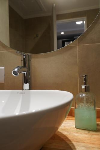 a bathroom sink with a bottle of soap in front of a mirror at Patagonia Oeste in San Carlos de Bariloche