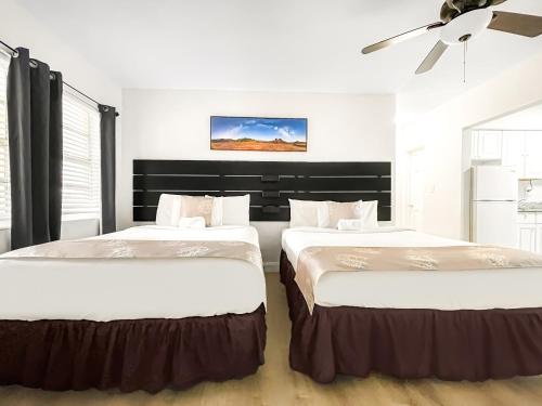 two beds in a room with white walls at The Flamingo in Hollywood