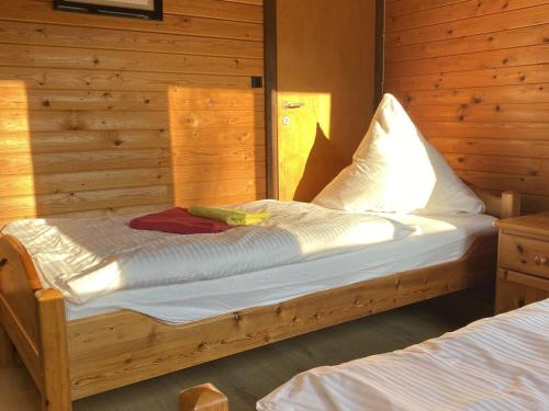 ein Holzbett in einem Zimmer mit Spiegel in der Unterkunft Cozy holiday home on a horse farm in the Lüneburg Heath in Eschede