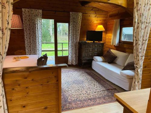 a living room with a couch and a tv in a cabin at Cozy holiday home on a horse farm in the Lüneburg Heath in Eschede