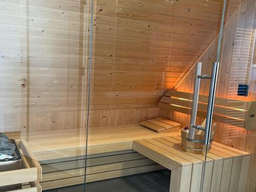 eine Holzsauna mit einer Holzbank in einem Zimmer in der Unterkunft Beautiful wellness villa with sauna, on a holiday park on the Tjeukemeer in Delfstrahuizen