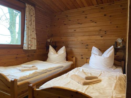 two beds in a log cabin with towels on them at Cozy holiday home on a horse farm in the Lüneburg Heath in Eschede