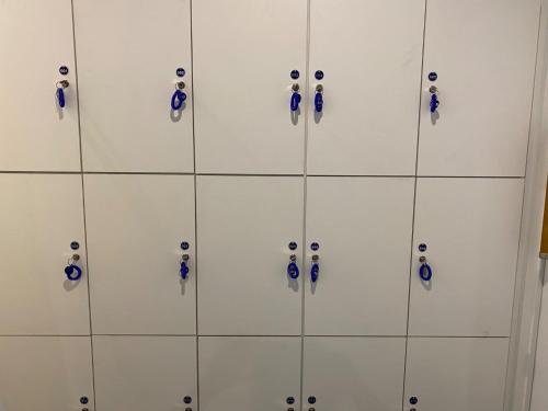 a wall of white cabinets with blue handles at Capsule in Kasakake MALE ONLY - Vacation STAY 72924v in Midori