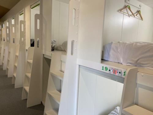 a room with rows of white bunk beds at Capsule in Kasakake MALE ONLY - Vacation STAY 72924v in Midori