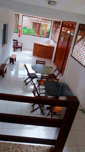 a room with a table and chairs and windows at Pousada da Adélia in Itaúnas