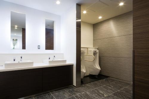 a bathroom with two sinks and a toilet at Hotel Sunroute Chiba in Chiba