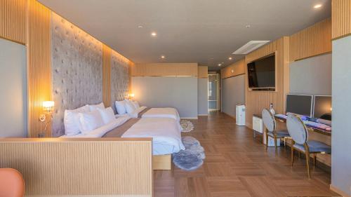 a hotel room with a large bed and a desk at Yeongdo Grandbern Hotel in Busan