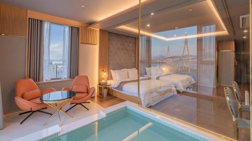 a hotel room with a bed and a swimming pool at Yeongdo Grandbern Hotel in Busan