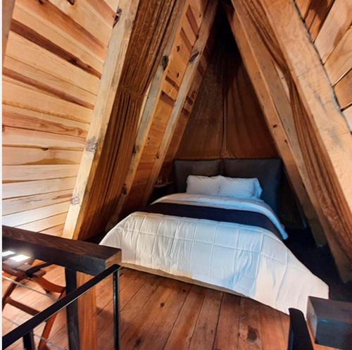 1 cama en una habitación en una casa de madera en Hotel Sierra Tigre, en Mazamitla