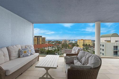 a living room with a couch and chairs on a balcony at Sandy Cove Apartment The Entrance 48a in The Entrance