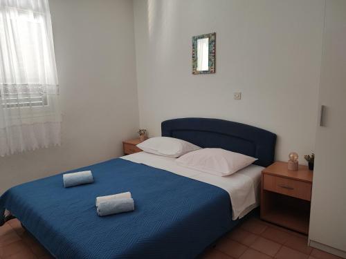 a bedroom with a blue bed with two towels on it at Apartments and rooms with parking space Zavala, Hvar - 128 in Jelsa