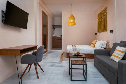 a living room with a couch and a bed at Rodina Boutique Hotel in Playa del Carmen