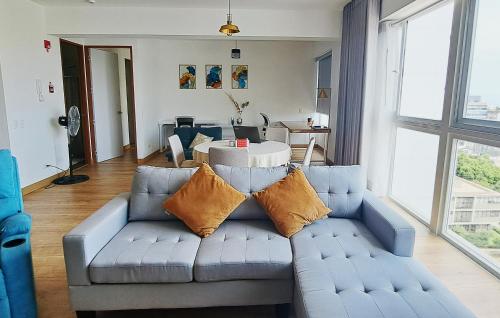 uma sala de estar com um sofá azul com almofadas em VK Loft - Apartamento en Miraflores em Lima