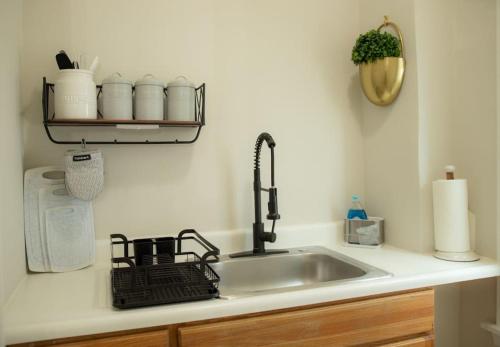 a kitchen sink with a faucet and a shelf at Cozy Getaway in Everett