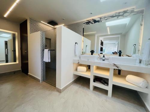 a bathroom with two sinks and a large mirror at Marisol Hotel Boutique in San José del Cabo