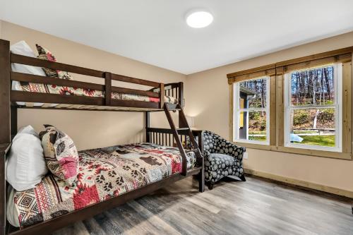 a bedroom with two bunk beds and a chair at Whispering Winds in Gatlinburg