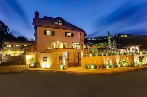 une grande maison avec des lumières devant elle dans l'établissement Villa Boréal Hostellerie, à Águas de Lindóia