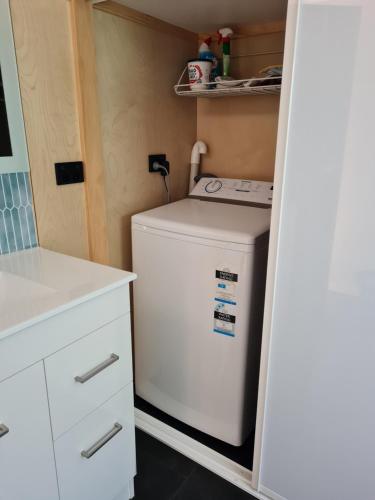 uma pequena máquina de lavar e secar roupa branca numa pequena cozinha em Kaiteriteri Tiny Home em Kaiteriteri