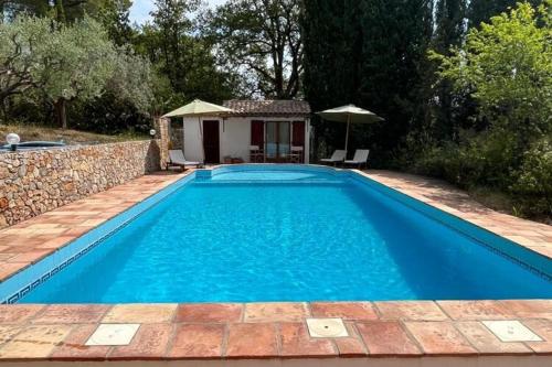 una gran piscina azul en un patio en Farmhouse in Draguignan with terrace, en Draguignan