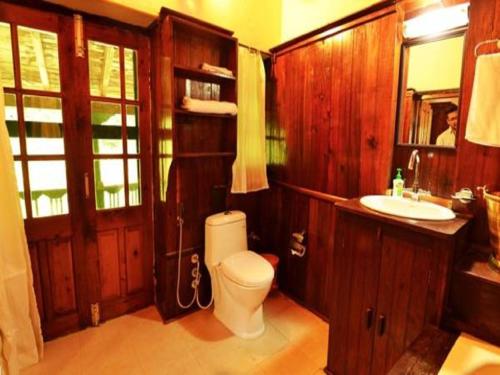 a bathroom with a toilet and a sink at Fredy's Bungalow near Nainital in Bhīm Tāl