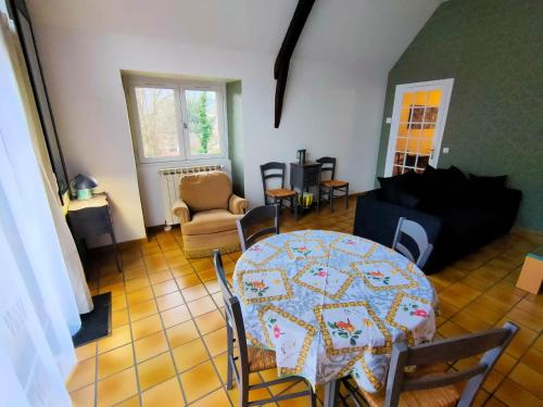 een woonkamer met een tafel en stoelen bij La Grange de Lili in Figeac