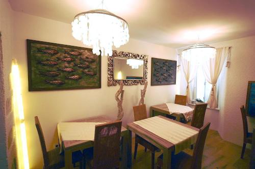 a dining room with two tables and a chandelier at Boutique Hotel Placa in Krk