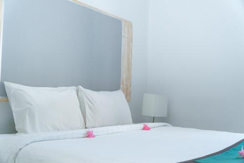 a large white bed with white pillows and a white headboard at Umadhatu Resort by Amerta in Tabanan