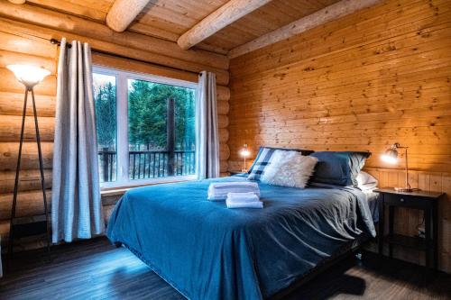 Llit o llits en una habitació de Les Chalets Tourisma - Chalet en bois rond avec spa et lac privé - Le Caribou