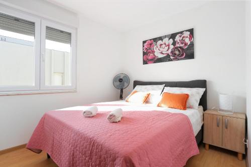 a bedroom with a large bed with a pink blanket at Apartments with WiFi Split - 20900 in Split
