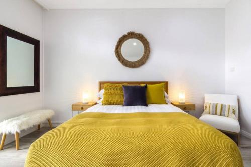 - une chambre avec un lit jaune et un miroir dans l'établissement Stylish Studio close to City, à Melbourne