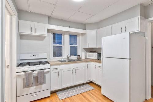 een keuken met witte kasten en een witte koelkast bij Charming Cuse home close to downtown & university in Syracuse