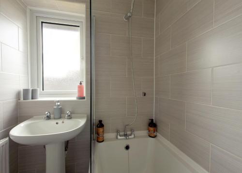 a white bathroom with a sink and a bath tub at Free Parking Large House Huyton Golf Club M57 in Roby