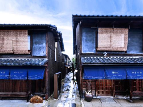 an alley between two buildings with blue roofs at Rinn Shiki Juraku in Kyoto