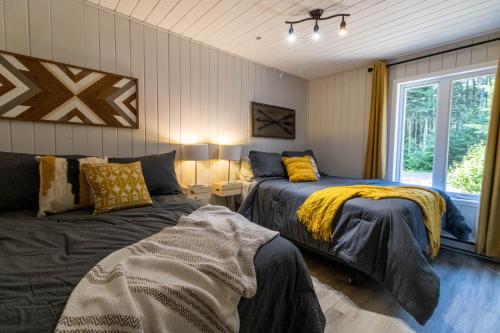 Postel nebo postele na pokoji v ubytování Les Chalets Tourisma - Chalet dans les bois avec lac privé - Le Colibri